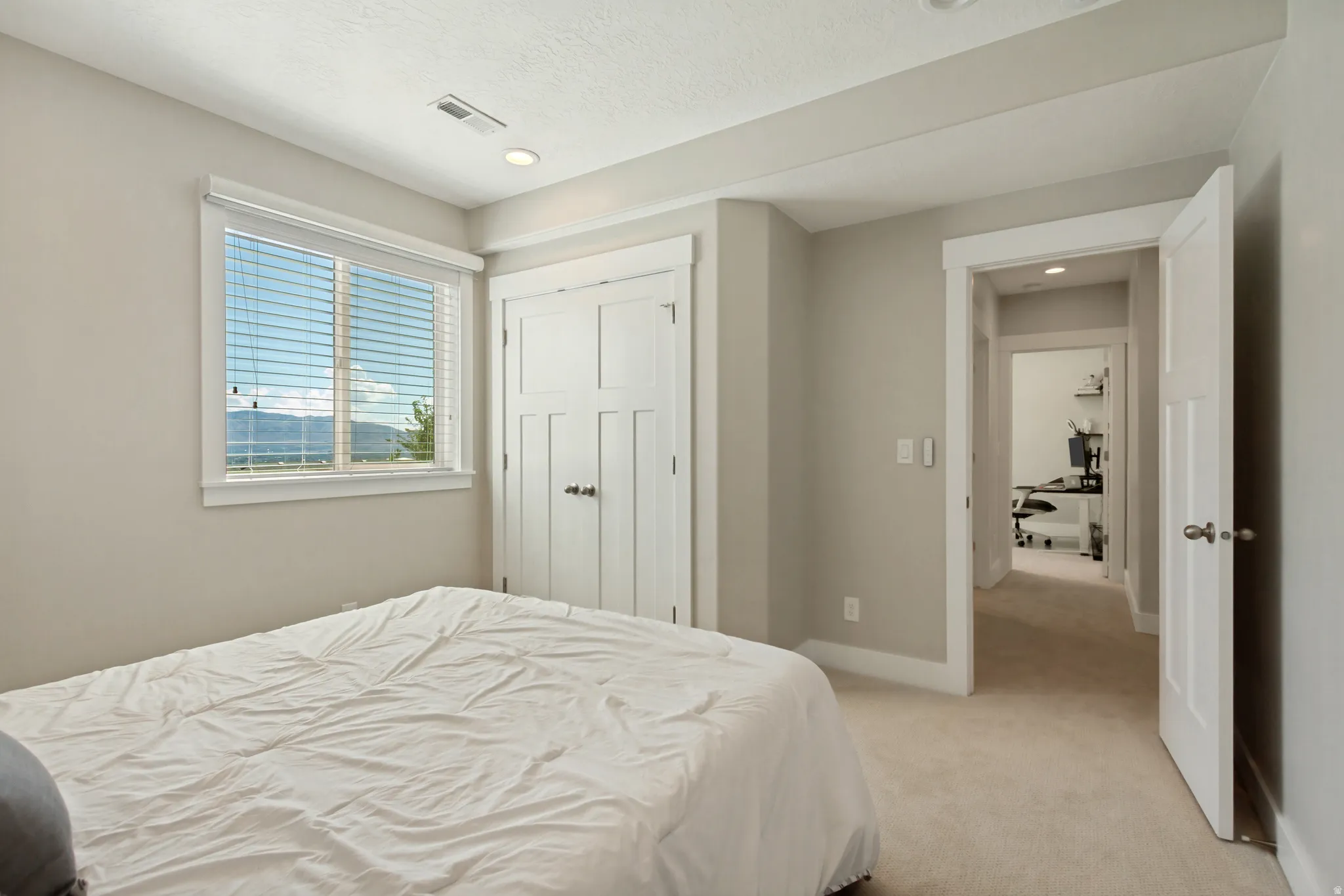 Neutral paint palette with recessed lighting, a window with horizontal blinds, and a built-in closet with panel doors