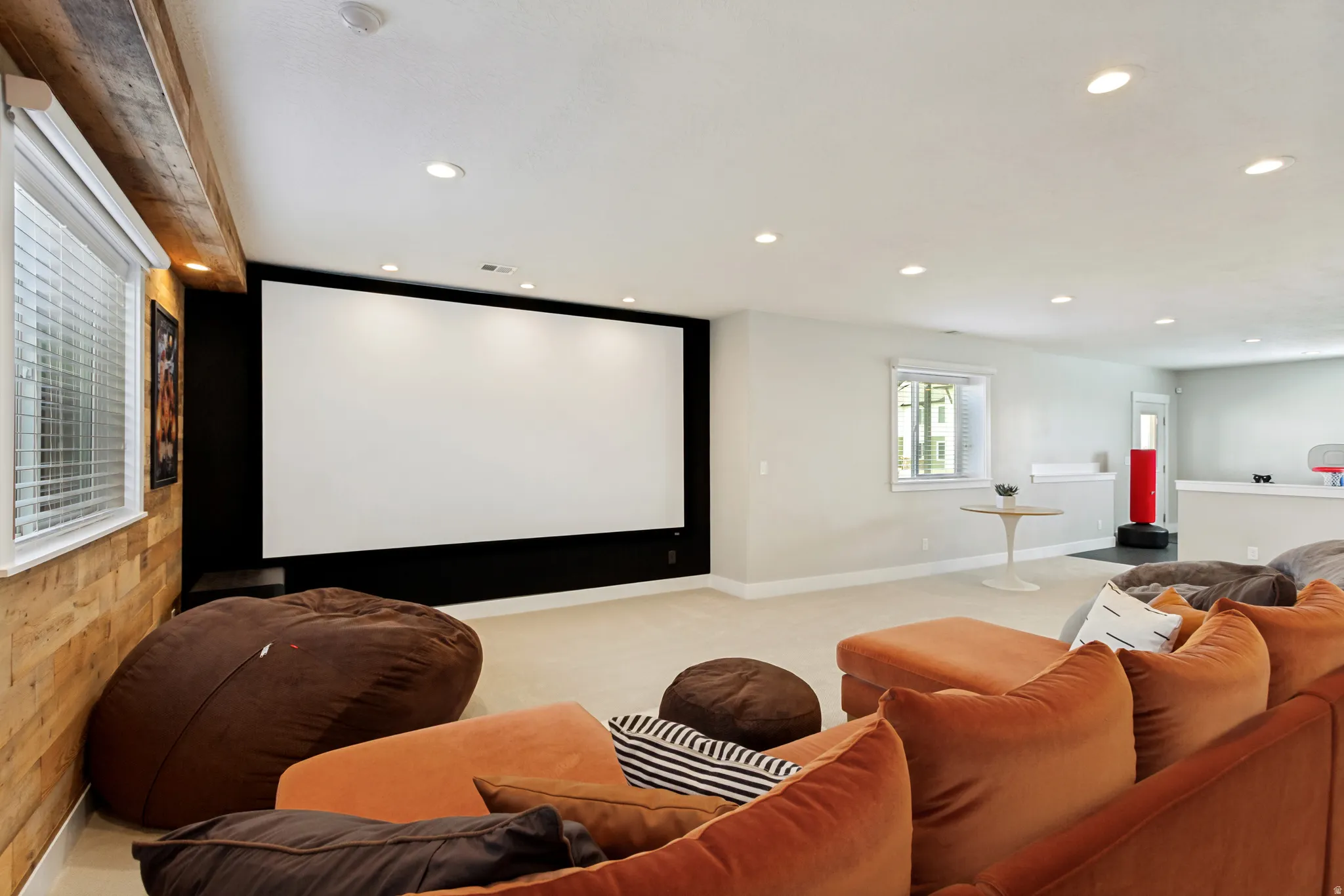 Large projection screen with an adjacent window, recessed lighting, and wall-mounted shelving