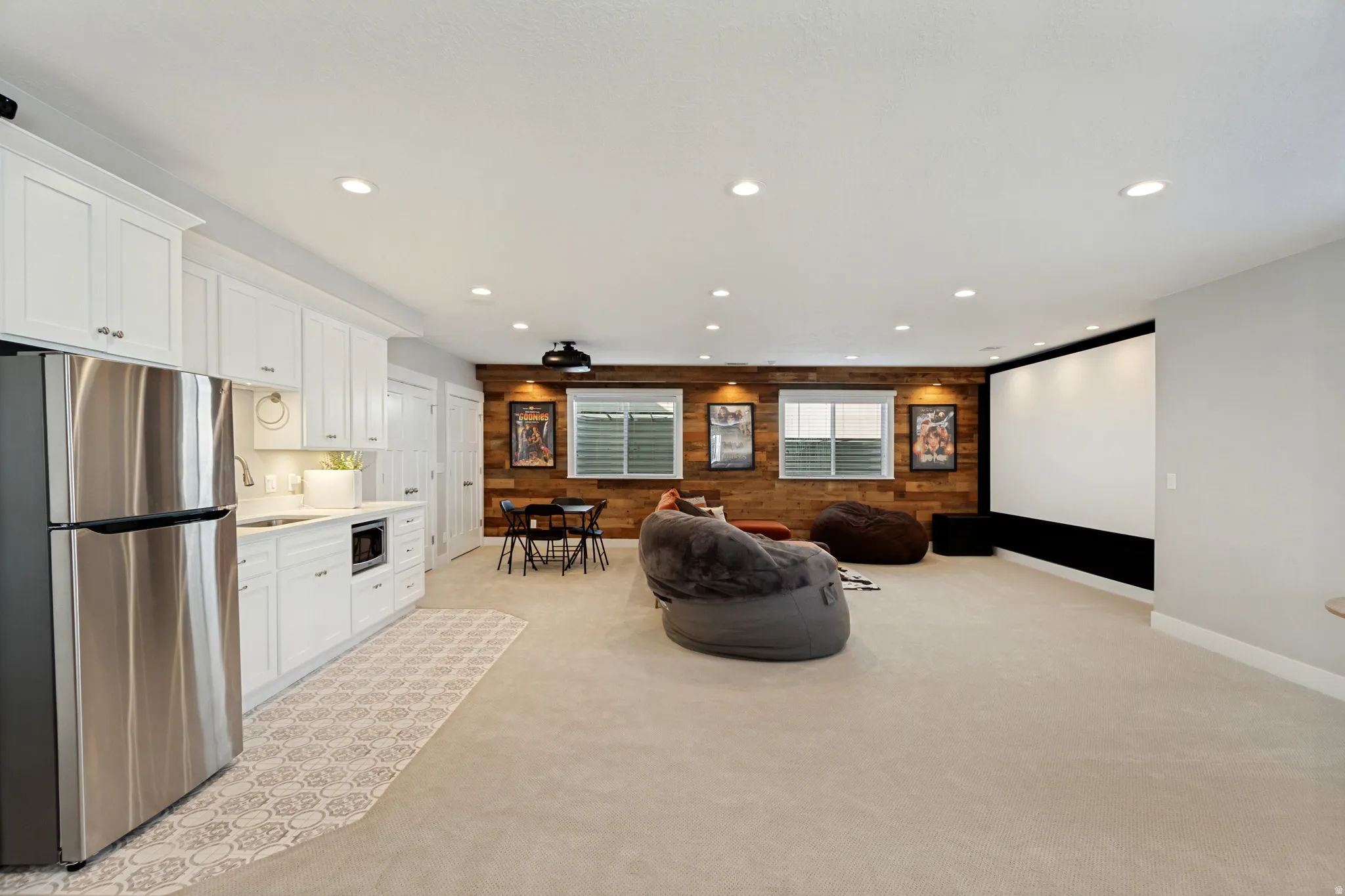 Integrated kitchenette with stainless steel refrigerator and white cabinetry