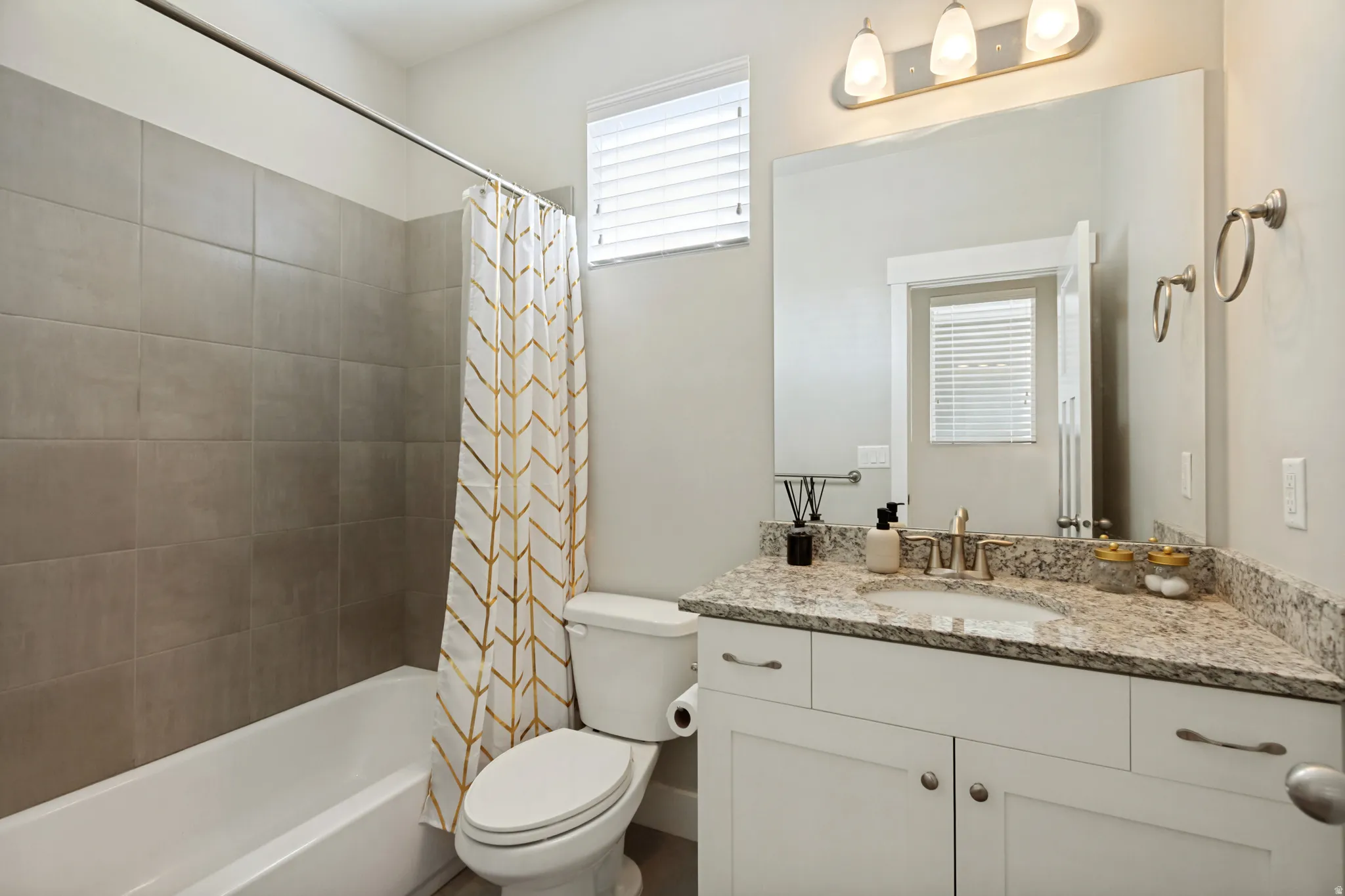 White vanity with a speckled countertop and undermount sink