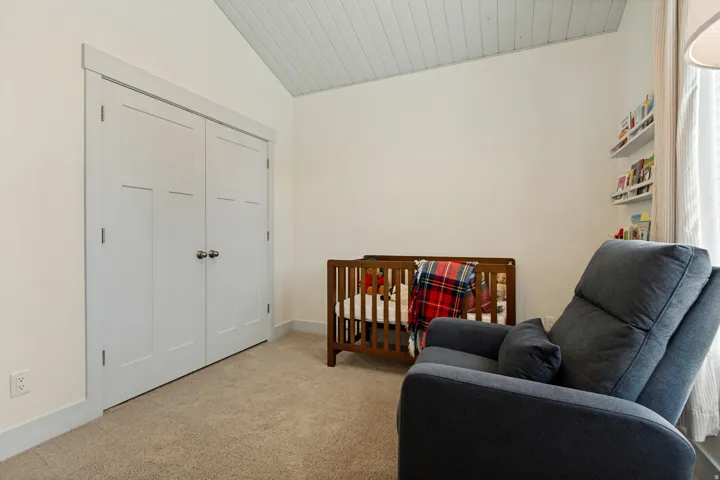 Sloped plank ceiling, double closet doors, carpeted flooring, and built-in shelving