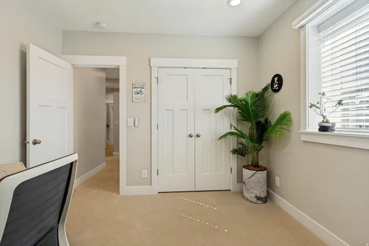 Carpeted room with white trim, a double-door closet, and a window with blinds
