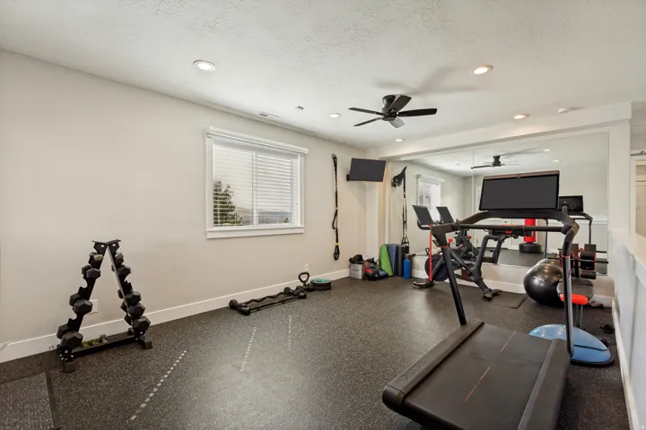 Dedicated fitness space featuring rubber flooring, recessed lighting, and a ceiling fan