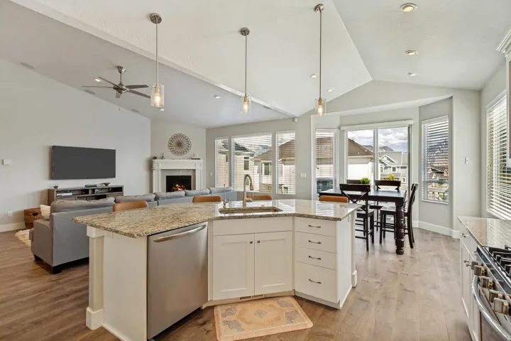 Expansive open-concept living area featuring a vaulted ceiling with recessed lighting and a ceiling fan