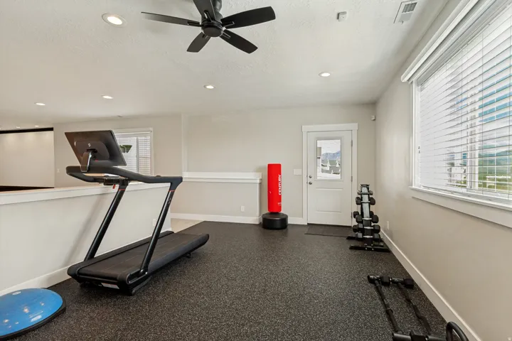 Recessed lighting, ceiling fan, opaque white window blinds, white window trim, and a white exterior door with glass paneling
