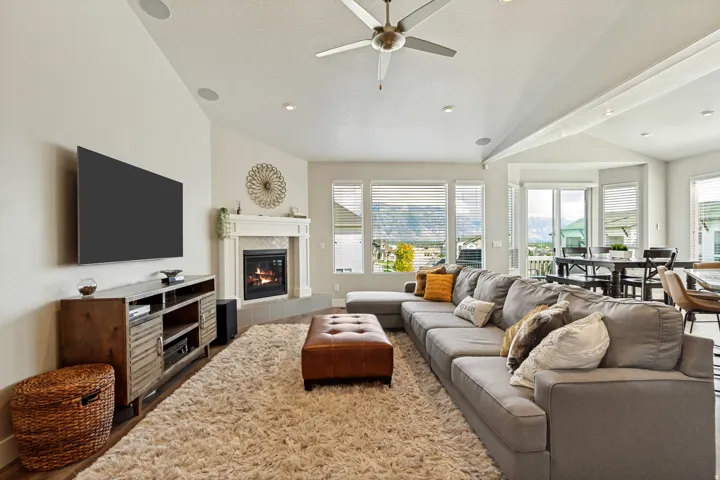 Vaulted ceilings, recessed lighting, and a built-in fireplace with a stone hearth