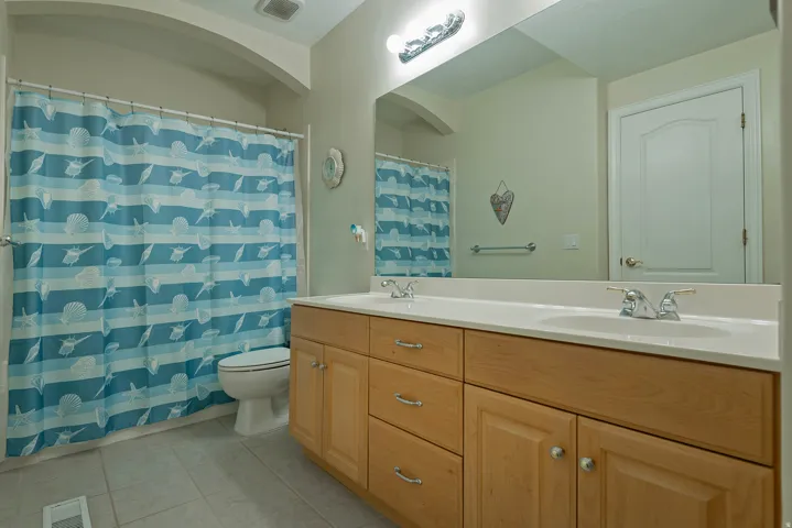 Dual vanity with light wood-finish cabinetry and integrated sinks