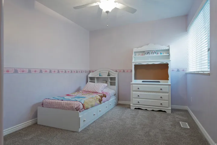 Carpeted room with a ceiling fan, a window with horizontal blinds, and light purple wall tones
