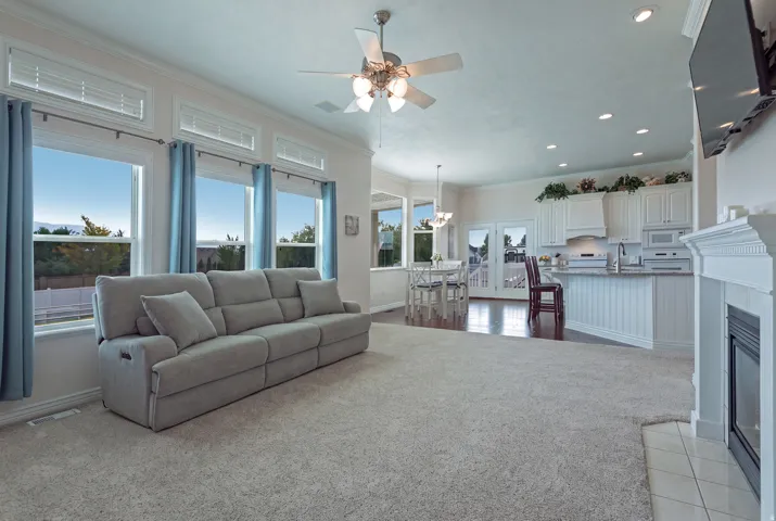 Open-concept living space featuring a fireplace, recessed lighting, and a ceiling fan