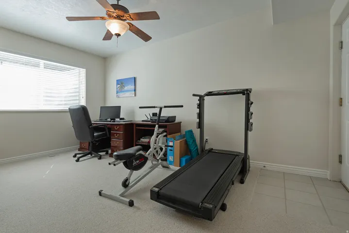 Recessed window with blinds, ceiling fan with integrated lighting, two-tone wall paint, and mixed flooring with carpet and tile sections