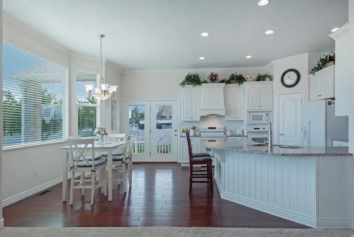 Kitchen featuring white cabinetry, built-in appliances, recessed lighting, and a peninsula with a stone countertop