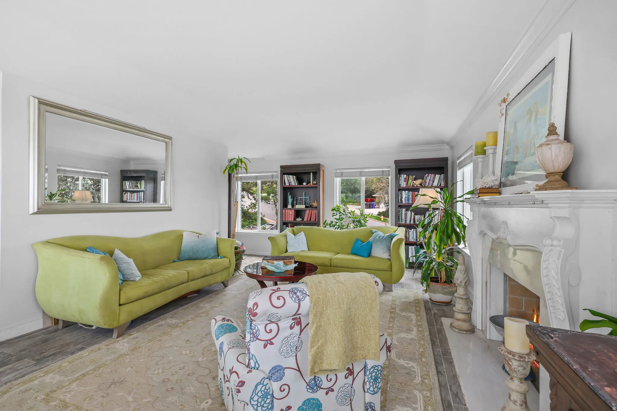 Living area with wood-finish flooring, a decorative fireplace, and built-in shelving units