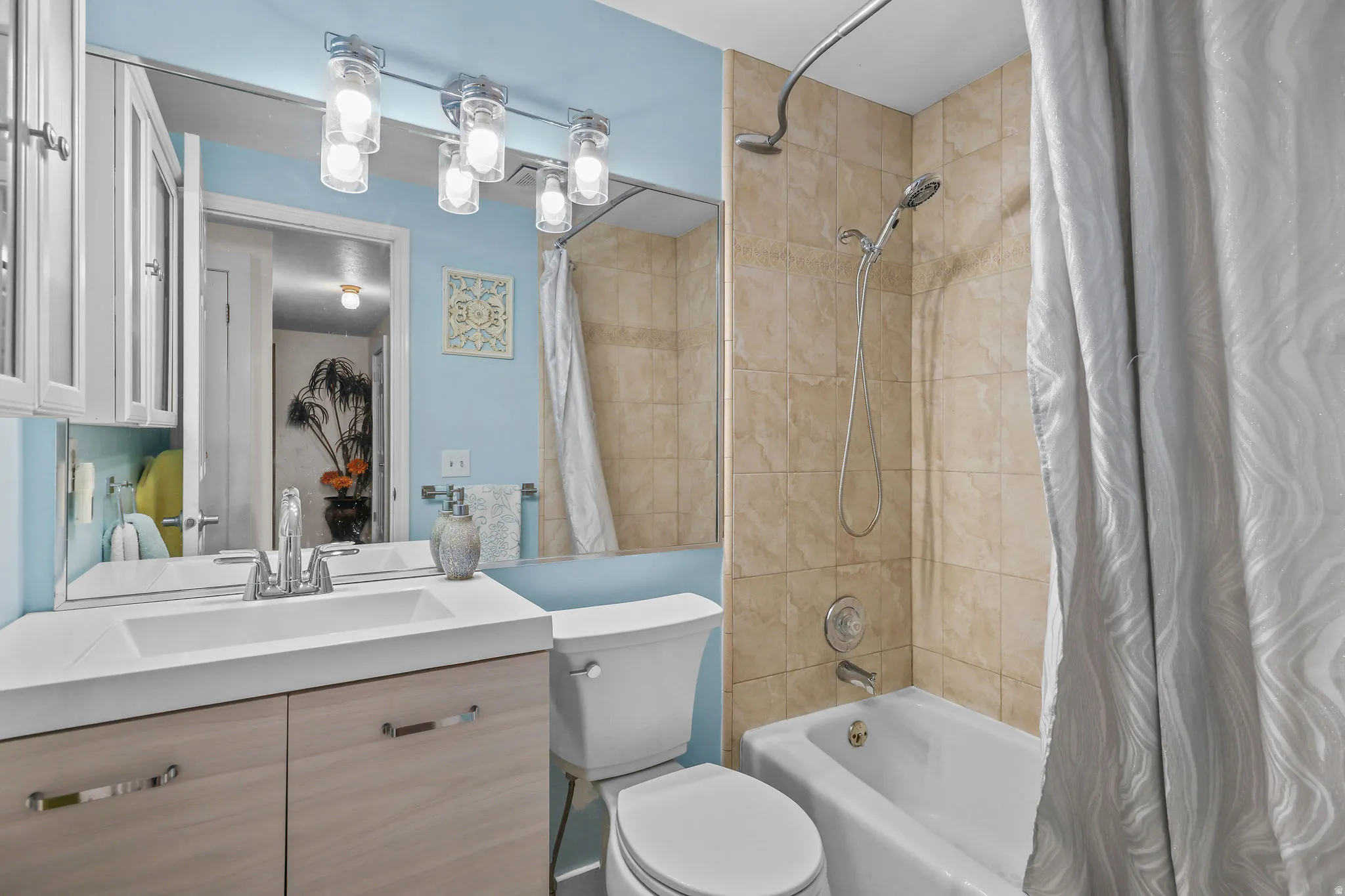 Vanity with integrated sink, wood-finish cabinetry, and chrome fixtures