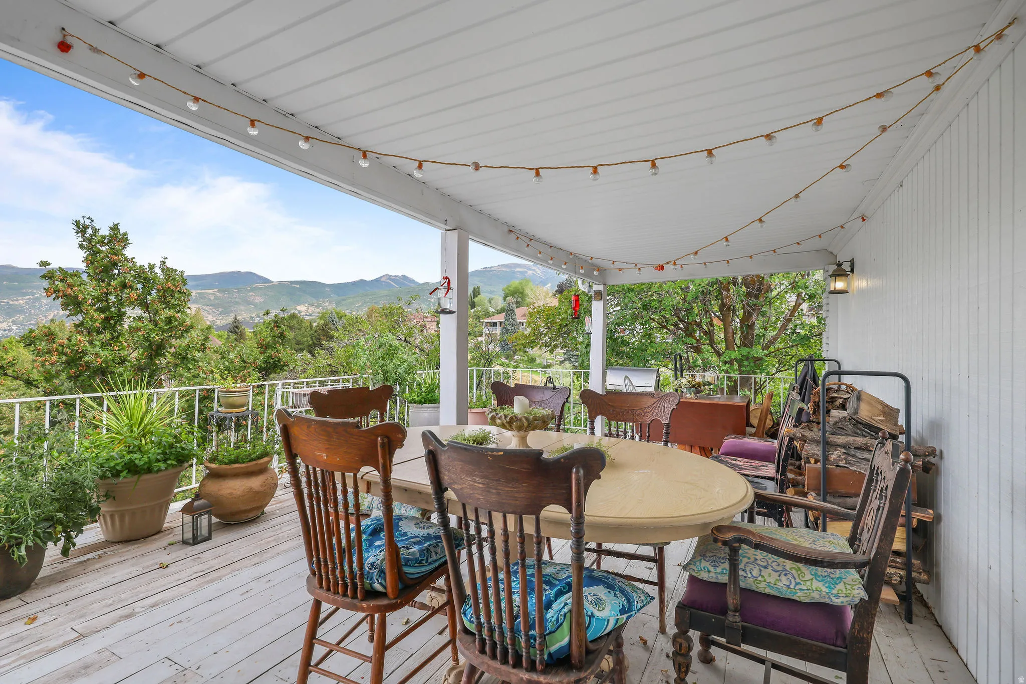 Covered deck featuring a painted wood floor, white railing, and exterior wall siding