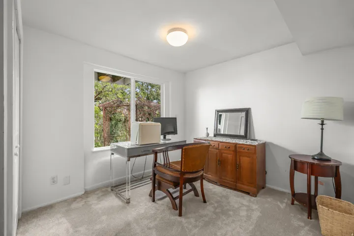 Recessed lighting, wood-finish cabinetry, built-in shelving, carpet flooring, and a large window