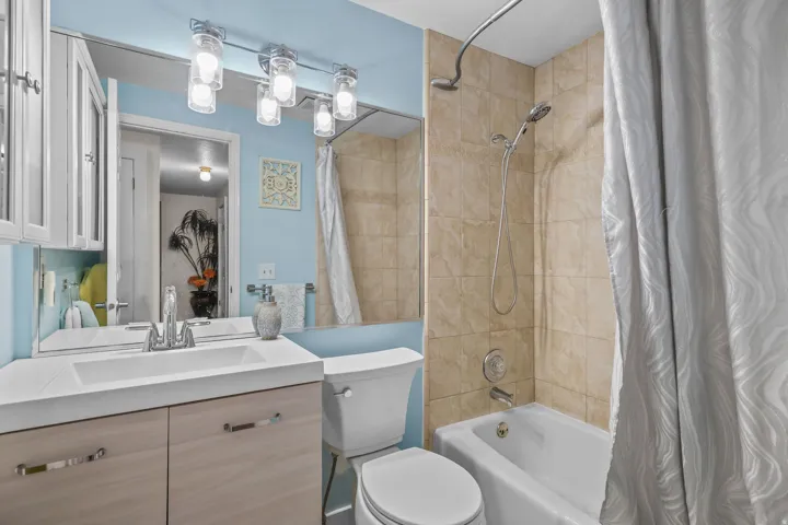 Vanity with integrated sink, wood-finish cabinetry, and chrome fixtures