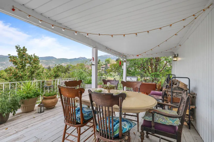 Covered deck featuring a painted wood floor, white railing, and exterior wall siding