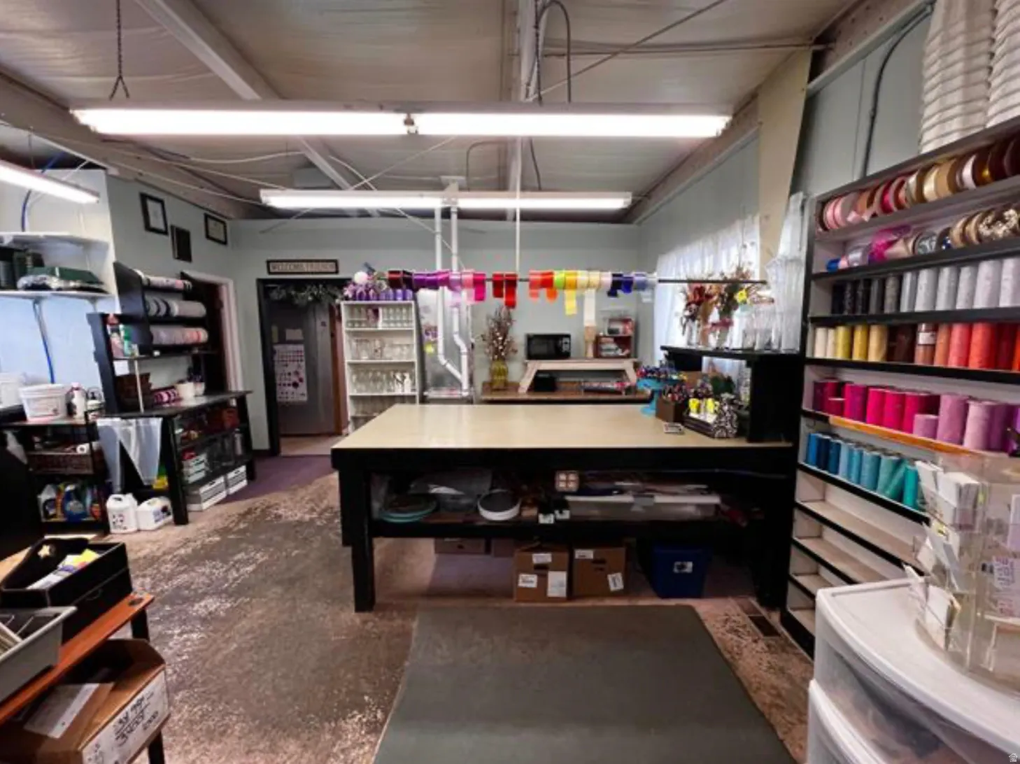 Fluorescent strip lighting, exposed ceiling beams, light-colored walls, and a durable floor surface