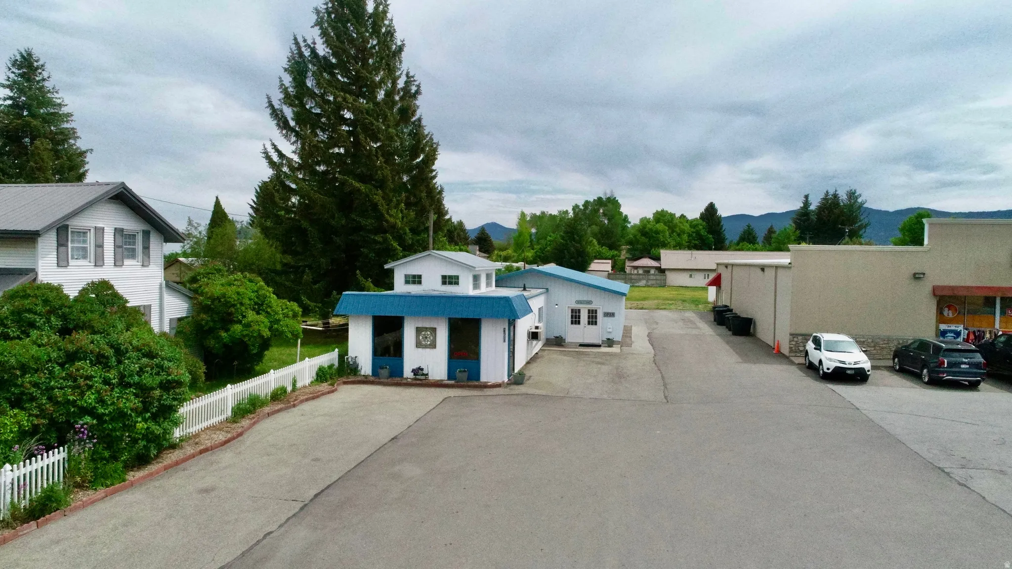 Paved parking area with white picket fencing