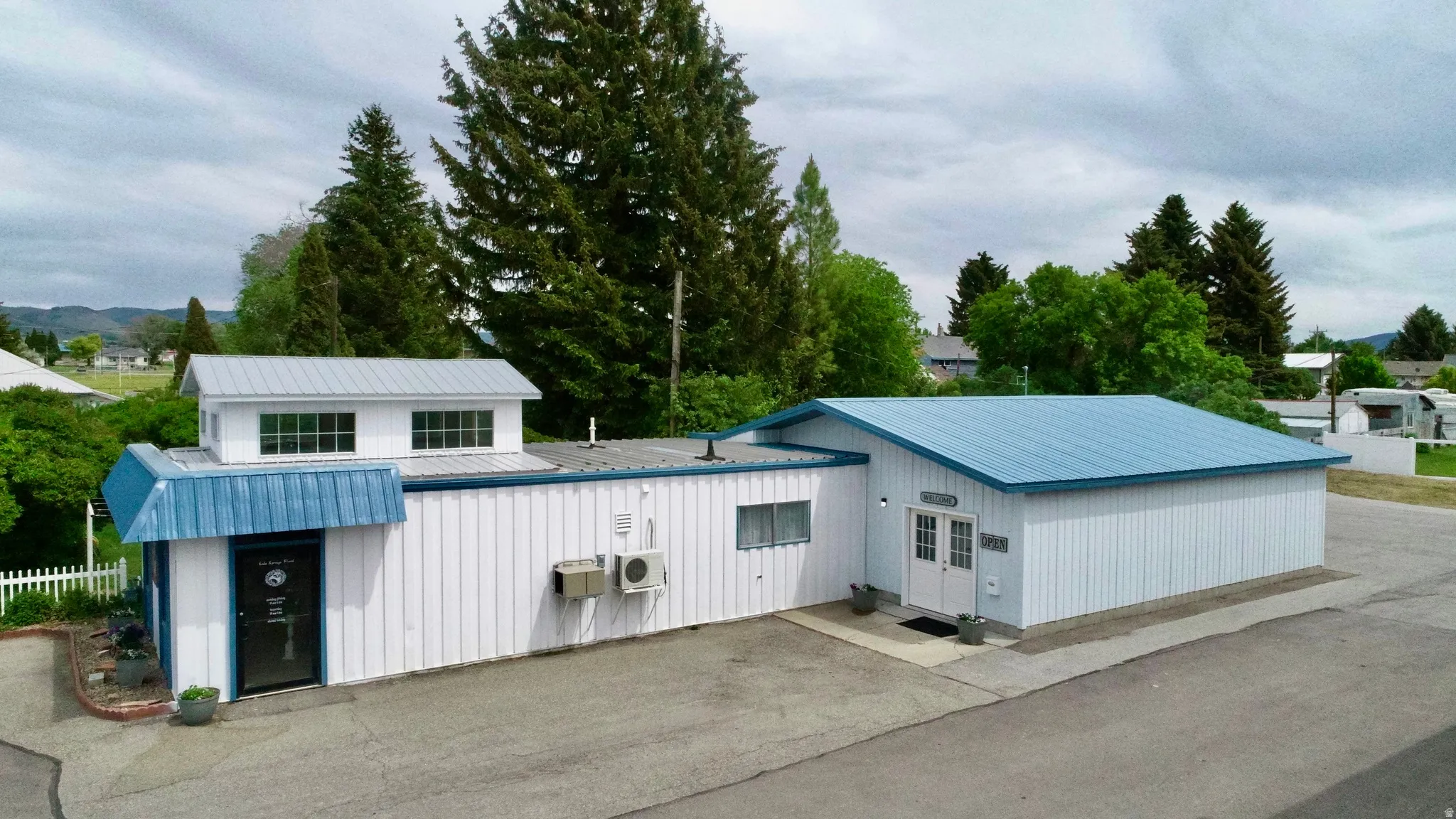 White corrugated metal siding exterior with a blue metal roof