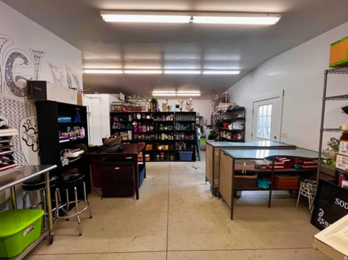 Spacious interior with concrete flooring and overhead fluorescent lighting