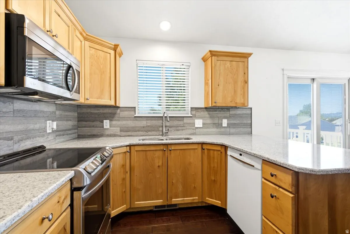 Wood-finish cabinetry paired with light-toned countertops and a tiled backsplash