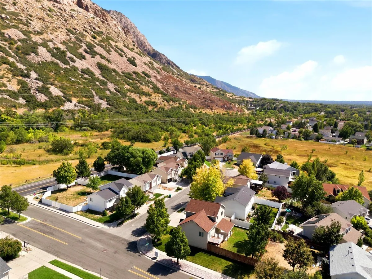 Neighborhood setting with a mountain backdrop, mature trees, and residential streets