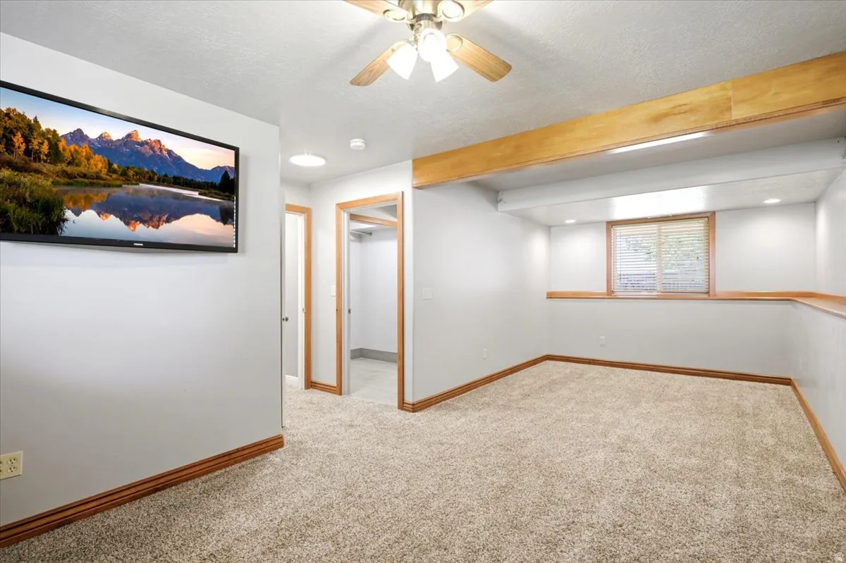 Carpeted room with recessed lighting and a window