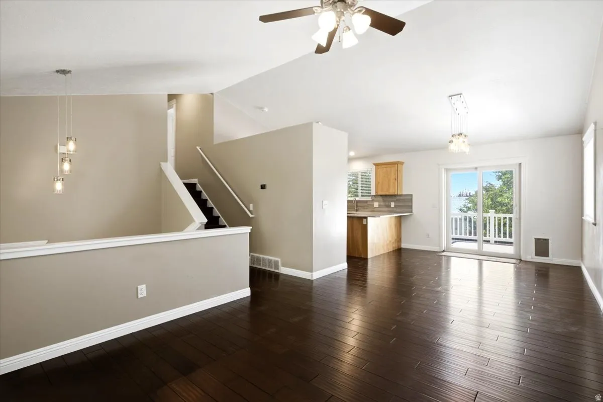 Hardwood-finish flooring, vaulted ceilings, and a sliding glass door to an outdoor deck