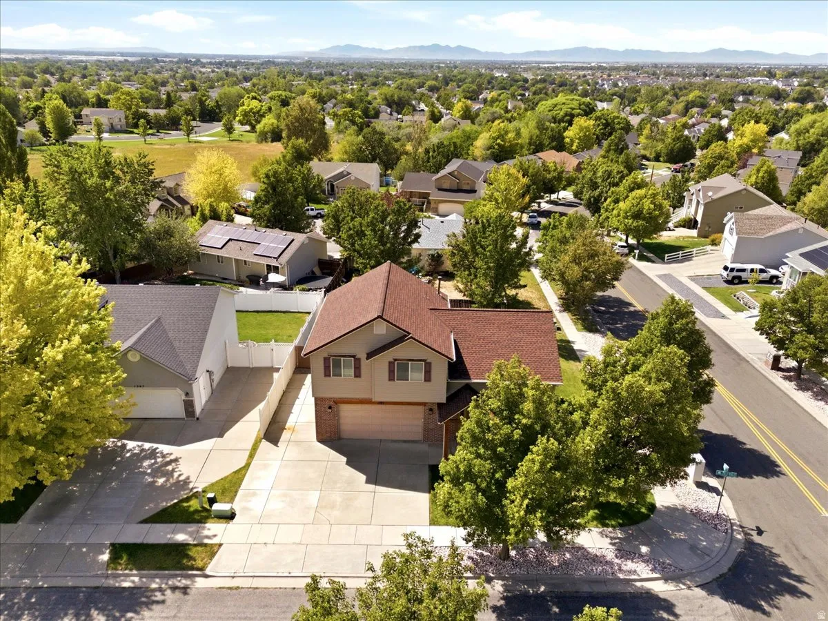 Two-story residence with a brown shingle roof, two-car garage, and mature landscaping