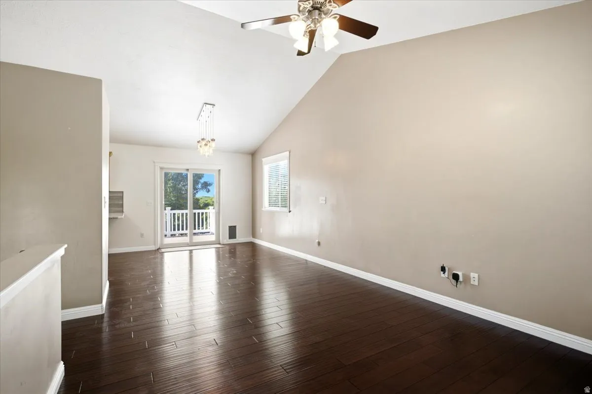 Vaulted ceiling with a ceiling fan, recessed lighting, wood-finish flooring, and white trim