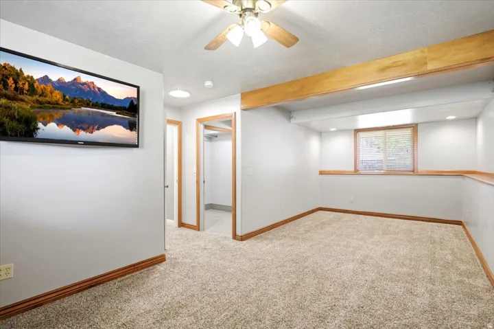 Carpeted room with recessed lighting and a window