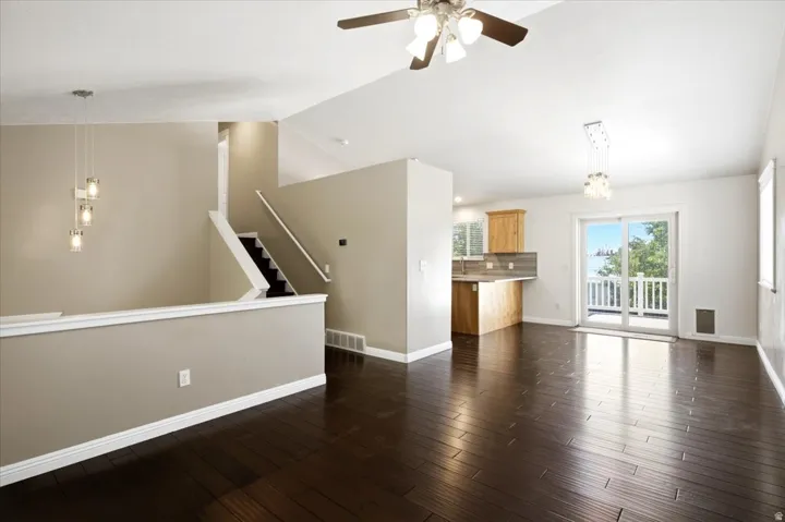 Hardwood-finish flooring, vaulted ceilings, and a sliding glass door to an outdoor deck