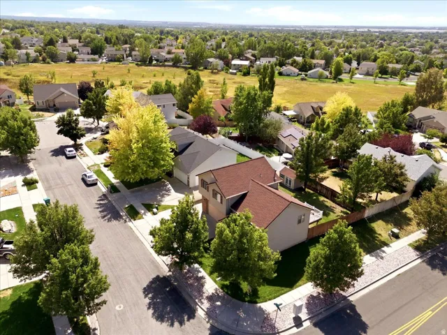 Corner lot property featuring a two-story design and a detached garage, surrounded by mature trees