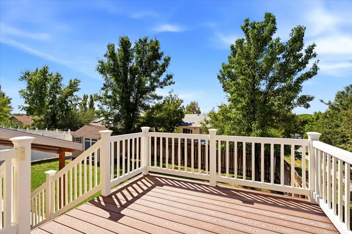 Expansive outdoor deck featuring wood-finish flooring and white railings
