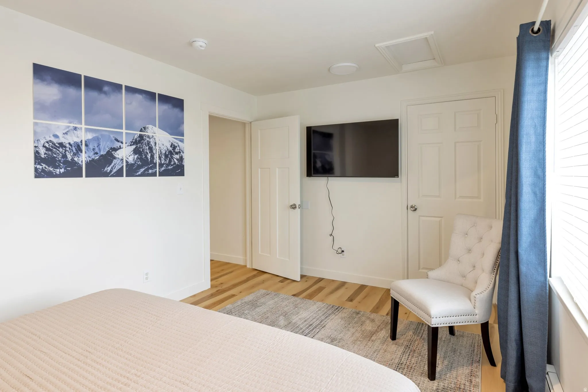 Light-toned wood-finish flooring, white walls, and white paneled interior doors