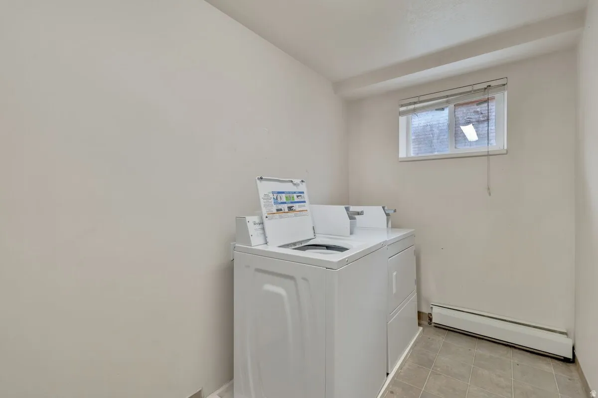 Laundry area featuring tiled flooring, a window, and a baseboard heater