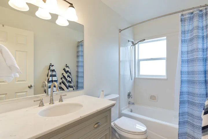White vanity with a light-colored countertop, undermount sink, and brushed nickel fixtures