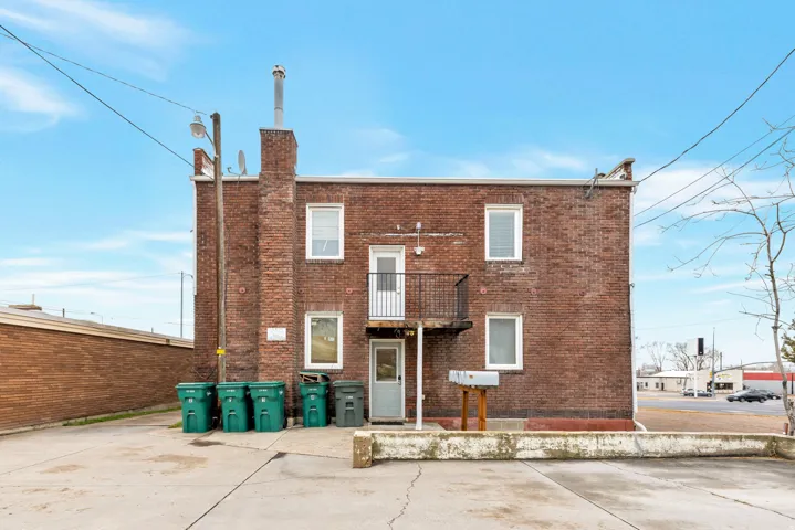 Brick exterior with multiple windows and a second-story balcony
