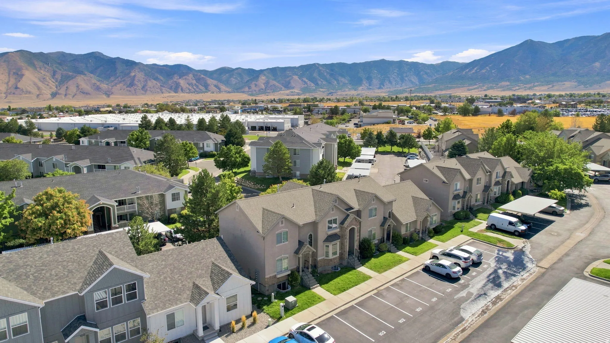 Residential community featuring multi-story townhomes with gabled roofs and manicured green spaces