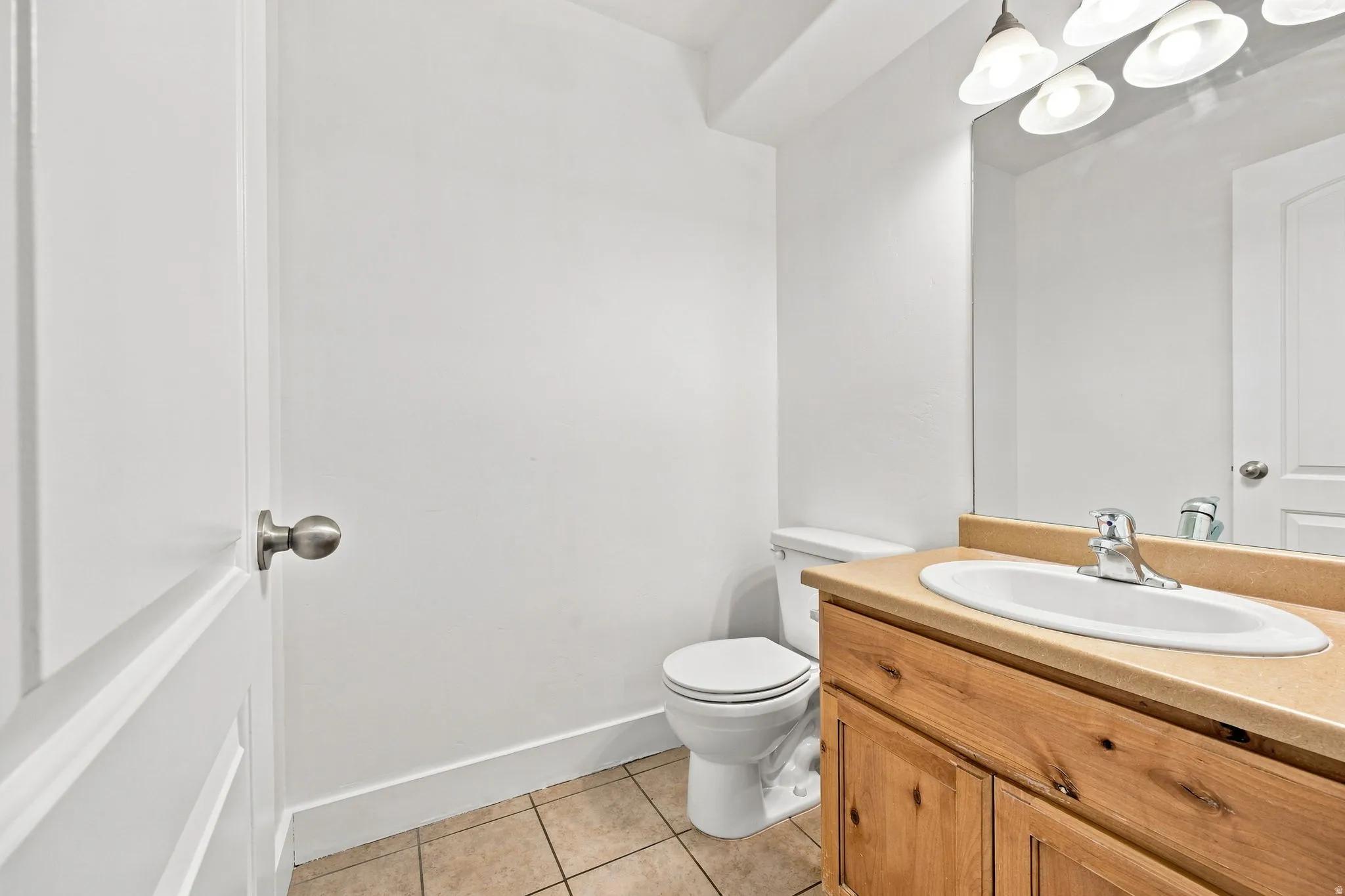 Vanity with wood-finish cabinetry, integrated sink, and brushed nickel faucet