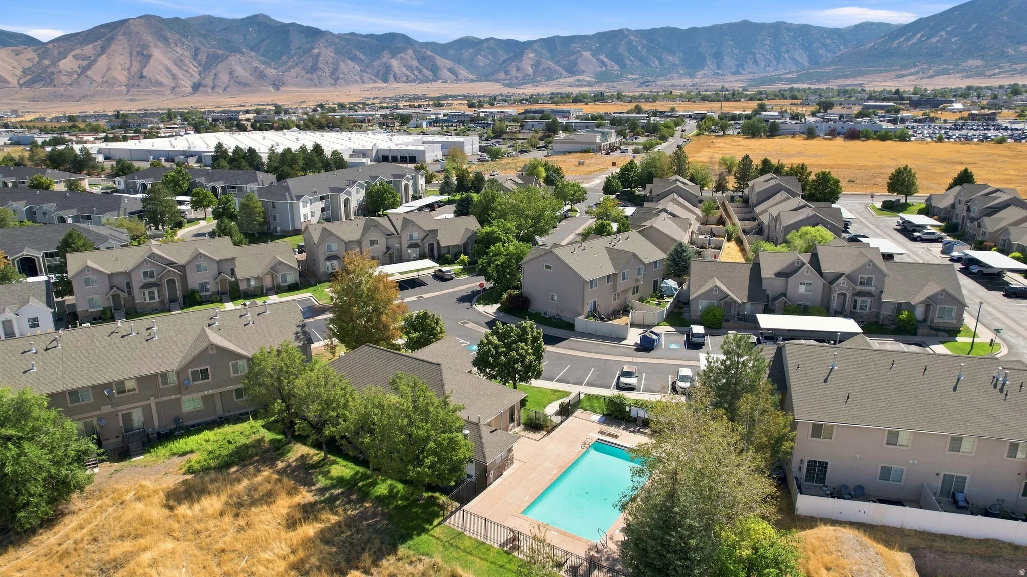 Community with multi-story residences, an outdoor swimming pool, and dedicated parking areas