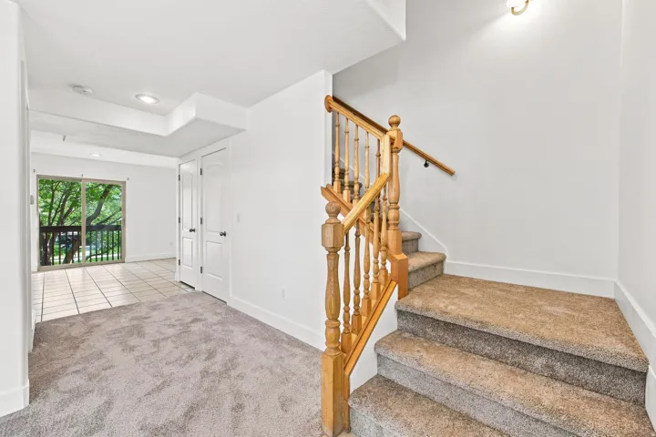 Carpeted stairs with wood-finish balustrade and handrail