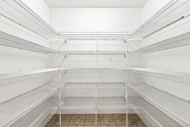 Expansive pantry featuring multi-level wire shelving, white walls, and tiled flooring
