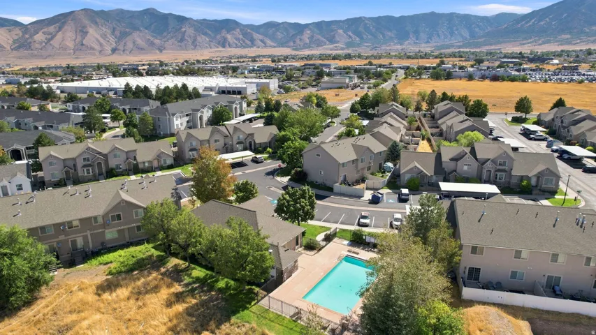 Community with multi-story residences, an outdoor swimming pool, and dedicated parking areas