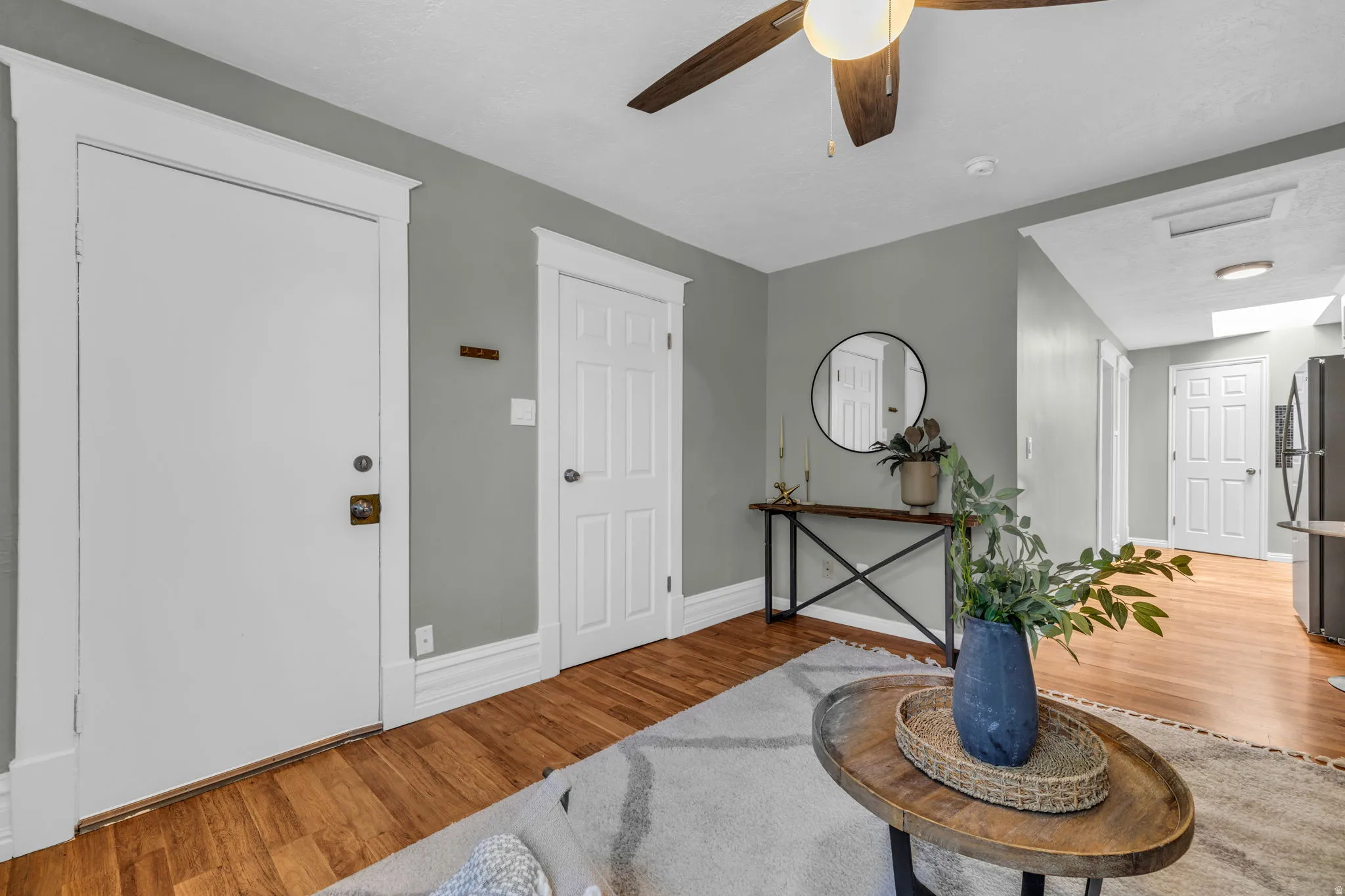 Warm wood-finish flooring, a ceiling fan with light fixture.