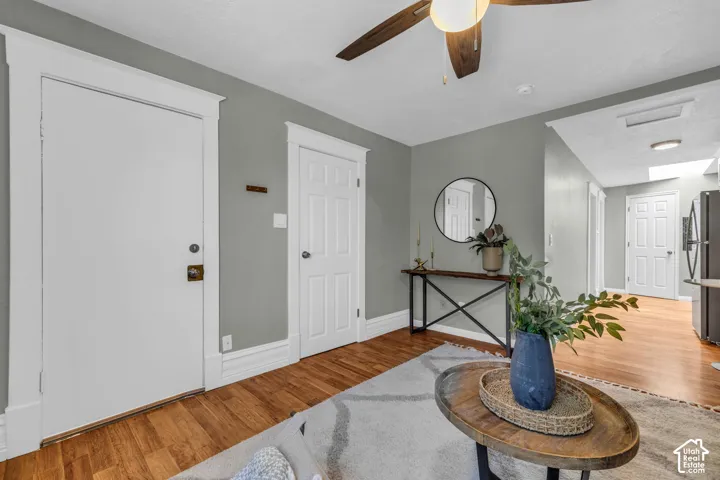 Warm wood-finish flooring, a ceiling fan with light fixture.