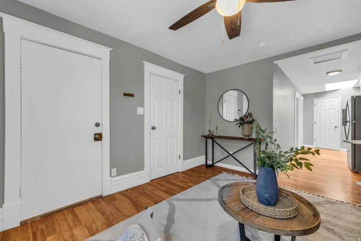Warm wood-finish flooring, a ceiling fan with light fixture.