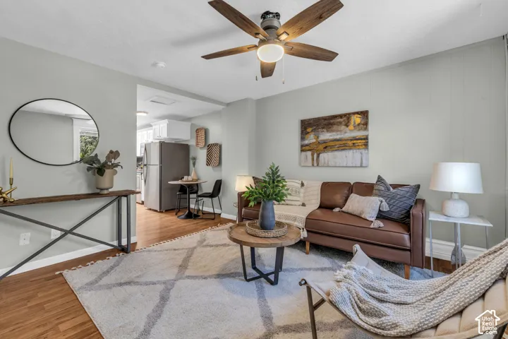 Wood-finish flooring, ceiling fan, board and batten wall accent, recessed lighting, and kitchen appliances