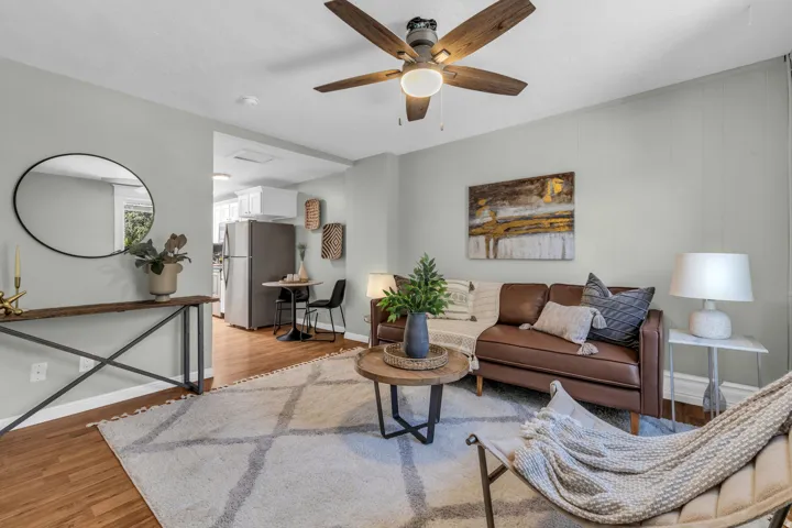 Wood-finish flooring, ceiling fan, board and batten wall accent, recessed lighting, and kitchen appliances